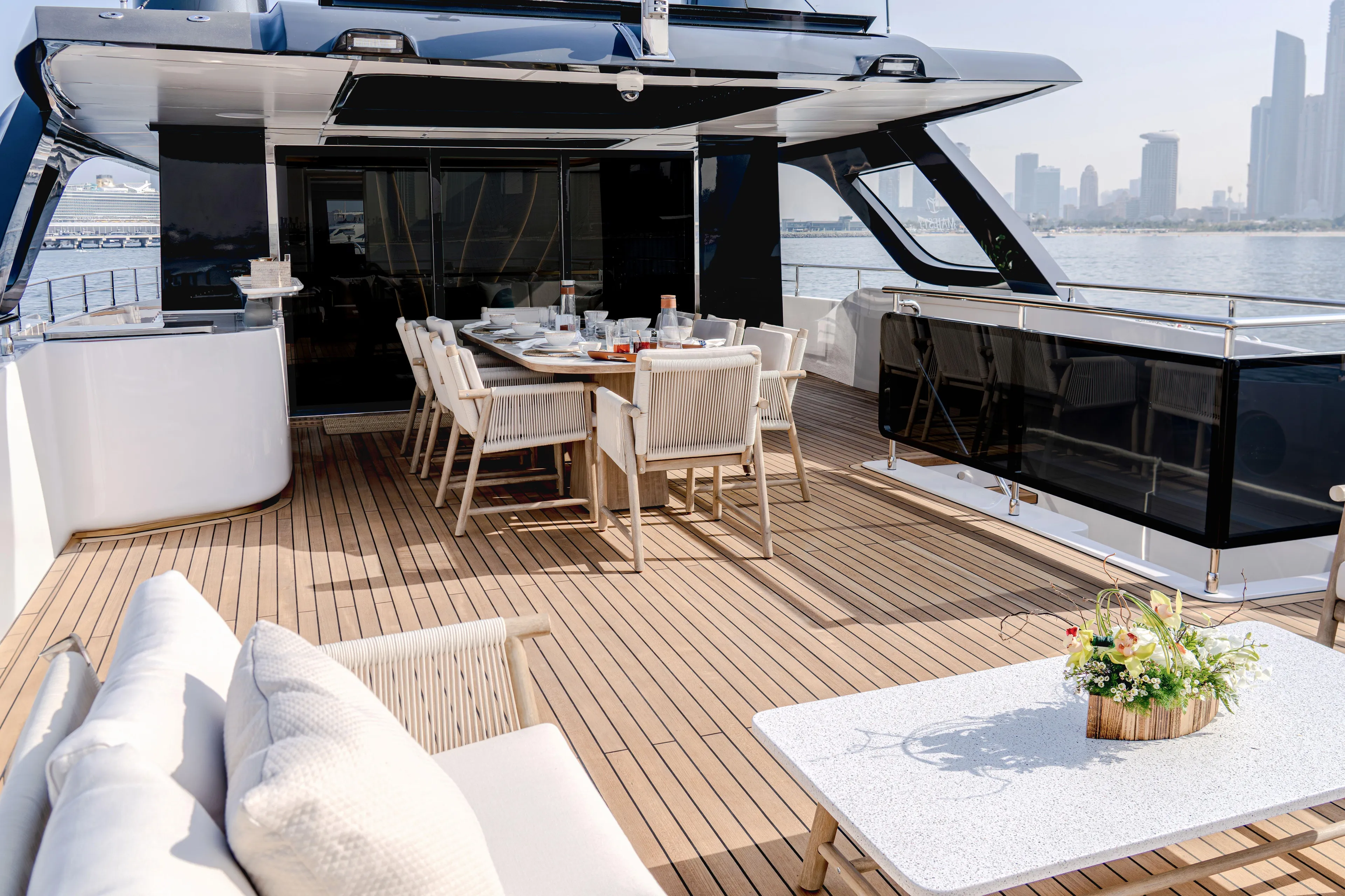  Yacht Photos Pics Luxurious 2027 Majesty 100 Terrace yacht deck with elegant dining setup and city skyline view.