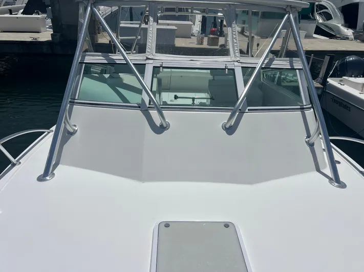  Yacht Photos Pics 2007 Topaz 32 Express boat docked, featuring sleek white deck and sturdy metal railings.