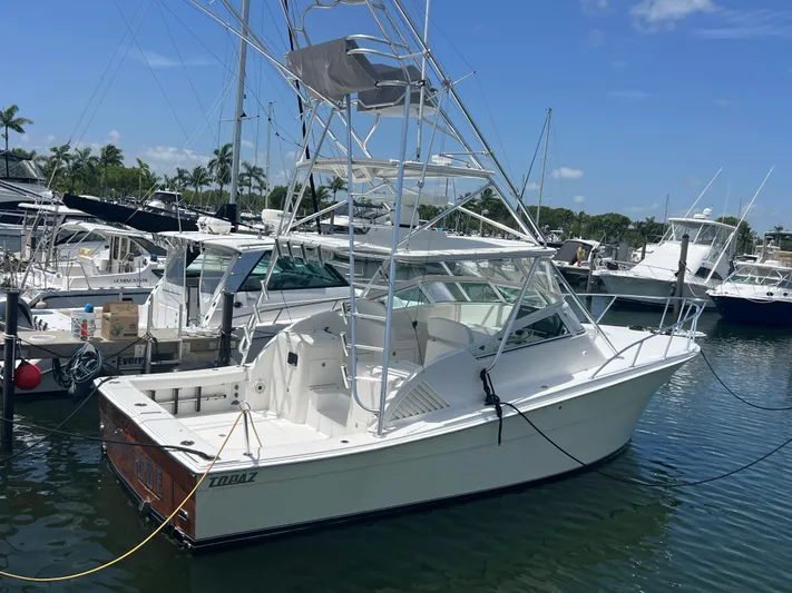  Yacht Photos Pics 2007 Topaz 32 Express boat docked in a marina, surrounded by other vessels.