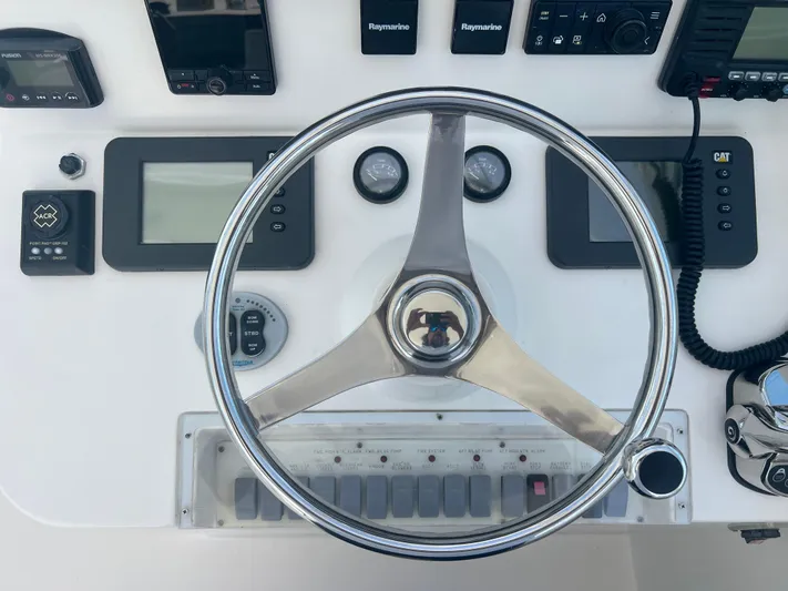  Yacht Photos Pics Steering wheel and control panel of 2007 Topaz 32 Express boat with navigation instruments.