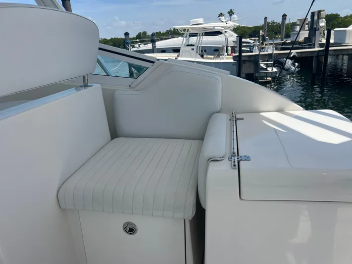  Yacht Photos Pics 2007 Topaz 32 Express boat interior with white seating and docked boats in the background.