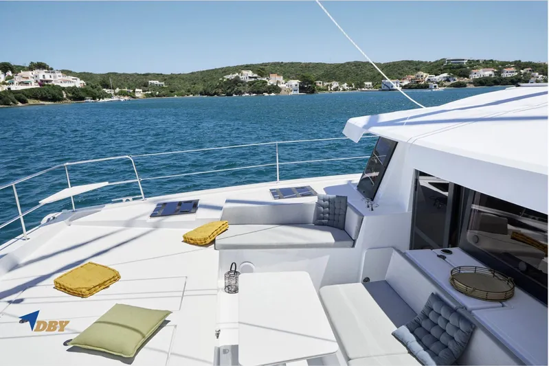 Ellidy Yacht Photos Pics Luxurious 2025 Bali 4.4 yacht deck with cushions, overlooking serene coastal waters.