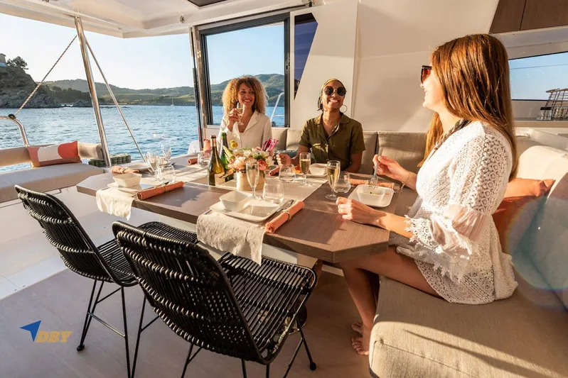 Ellidy Yacht Photos Pics Women enjoying a meal on a 2025 Bali 4.4 yacht, with ocean view.