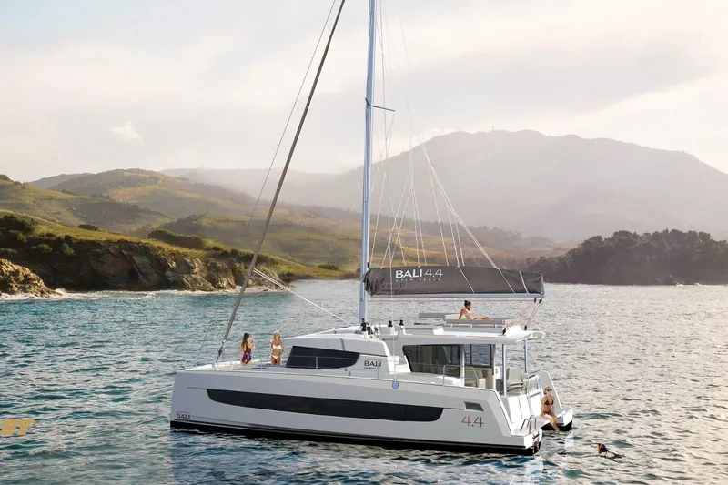 Ellidy Yacht Photos Pics 2025 Bali 4.4 catamaran sailing near scenic coastline with people enjoying the view.