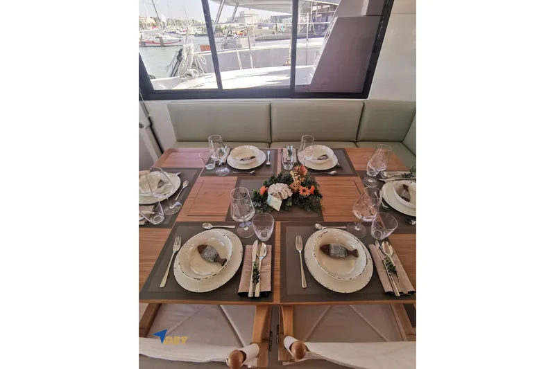 Ellidy Yacht Photos Pics Elegant dining setup on Bali 4.4 yacht, 2025 model, with floral centerpiece and marina view.