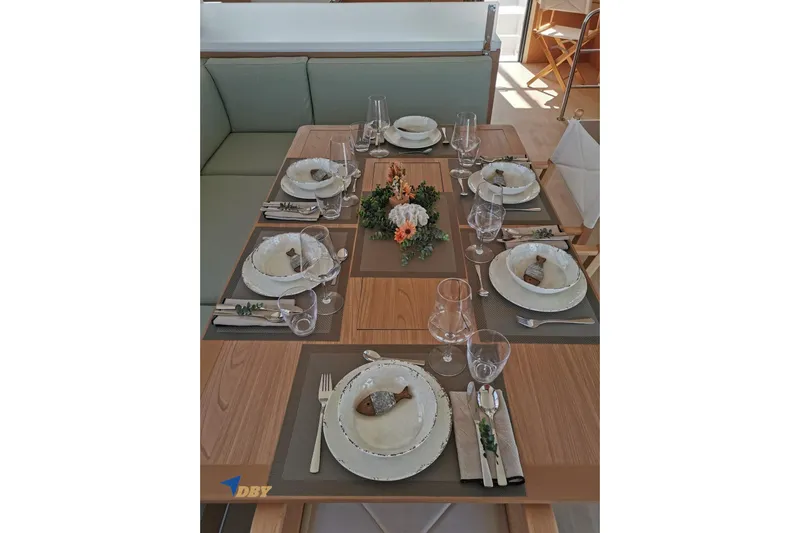 Ellidy Yacht Photos Pics Elegant dining setup on Bali 4.4 yacht, 2025 model, featuring floral centerpiece and fine tableware.