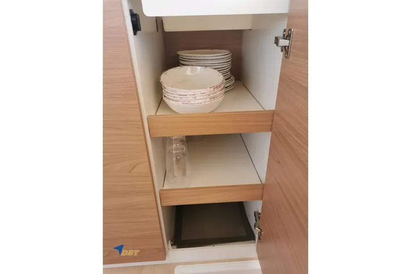 Ellidy Yacht Photos Pics Open wooden cabinet with stacked dishes and glasses, Bali 4.4 model, 2025.