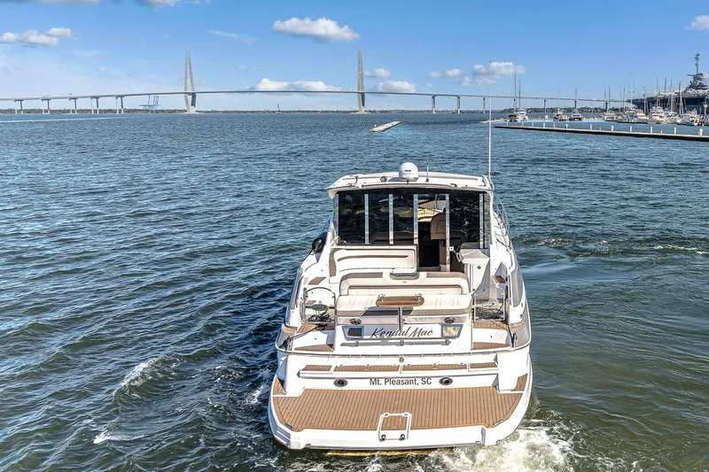  Yacht Photos Pics 2016 Regal 46 Sport Coupe yacht cruising near a bridge on a sunny day.