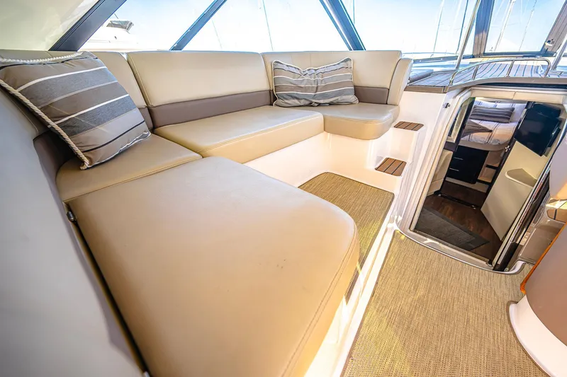  Yacht Photos Pics Luxurious interior of 2016 Regal 46 Sport Coupe with beige seating and striped cushions.