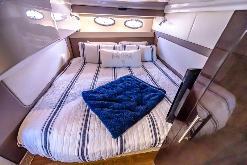  Yacht Photos Pics Luxurious bedroom interior of 2016 Regal 46 Sport Coupe yacht with striped bedding.