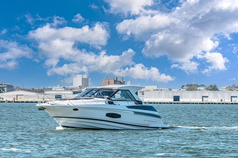  Yacht Photos Pics 2016 Regal 46 Sport Coupe cruising on a sunny day with cityscape background.