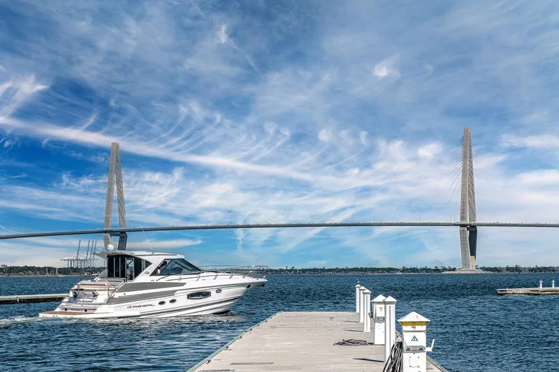  Yacht Photos Pics 2016 Regal 46 Sport Coupe cruising near a bridge under a clear blue sky.