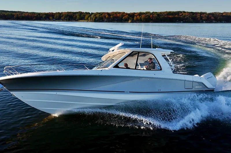  Yacht Photos Pics 2024 Boston Whaler 380 Realm cruising on a scenic lake with autumn foliage.