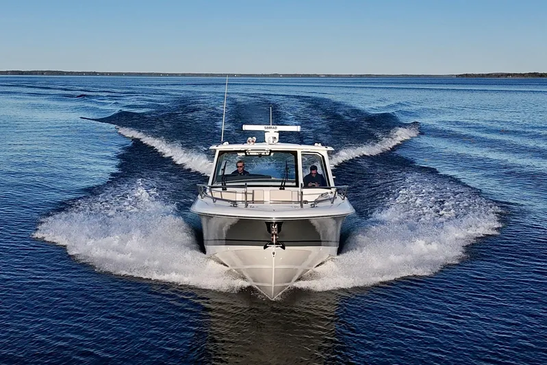  Yacht Photos Pics 2024 Boston Whaler 380 Realm cruising on open water, creating a dynamic wake.
