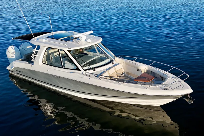  Yacht Photos Pics 2024 Boston Whaler 380 Realm boat on calm water, showcasing sleek design and luxury features.