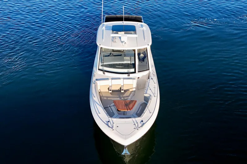  Yacht Photos Pics 2024 Boston Whaler 380 Realm boat on calm blue water, aerial view.
