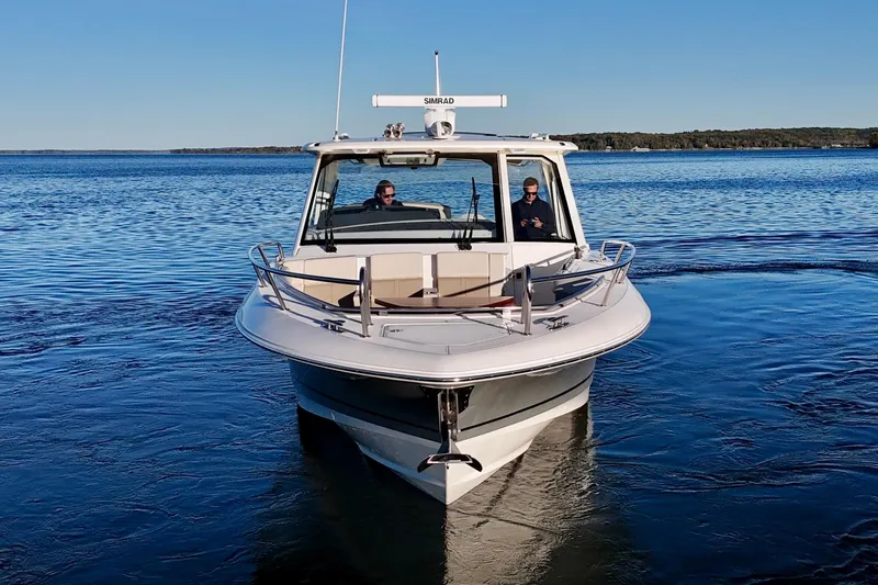  Yacht Photos Pics 2024 Boston Whaler 380 Realm cruising on a calm lake under clear blue skies.
