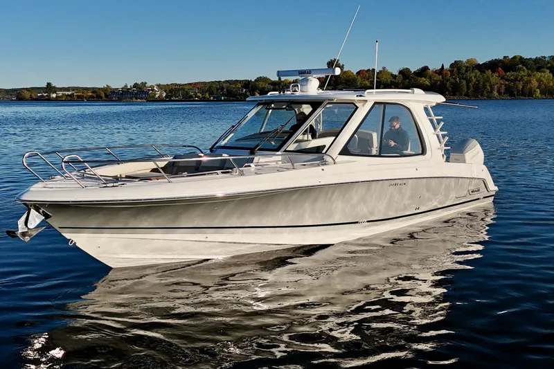  Yacht Photos Pics 2024 Boston Whaler 380 Realm boat on calm water, showcasing sleek design and luxury features.