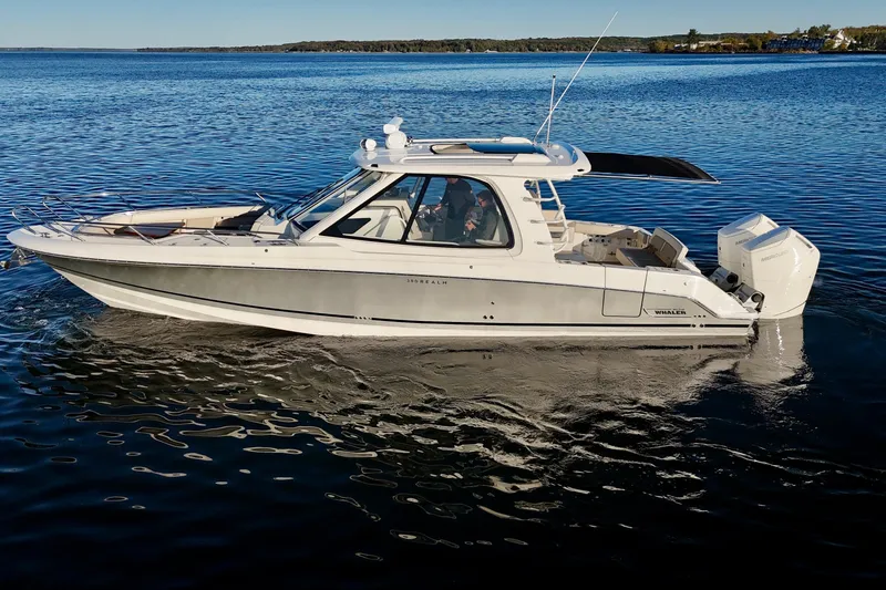  Yacht Photos Pics 2024 Boston Whaler 380 Realm boat cruising on a calm lake.