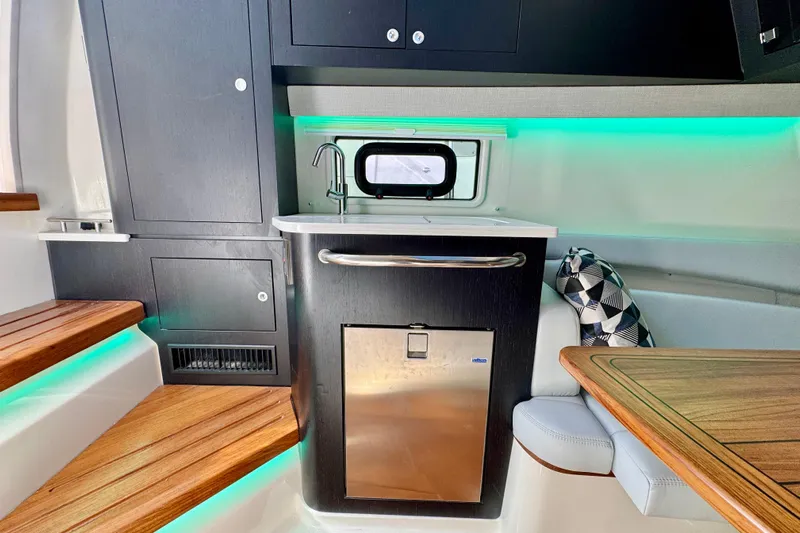  Yacht Photos Pics 2024 Boston Whaler 380 Realm interior with kitchenette, wooden steps, and ambient lighting.