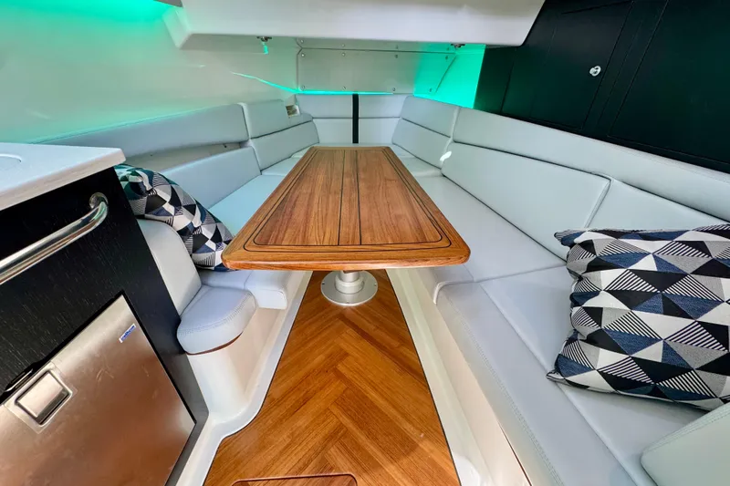  Yacht Photos Pics Luxurious interior of 2024 Boston Whaler 380 Realm with elegant seating and wooden table.