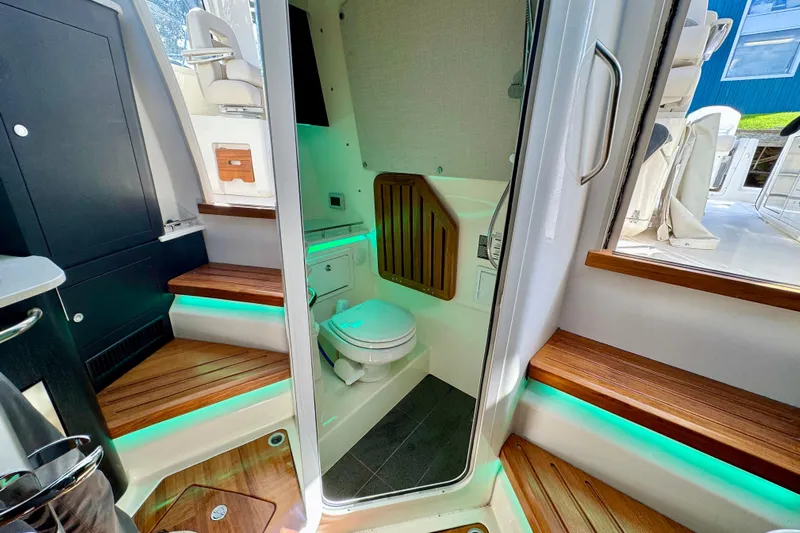  Yacht Photos Pics 2024 Boston Whaler 380 Realm interior with modern bathroom and wooden accents.