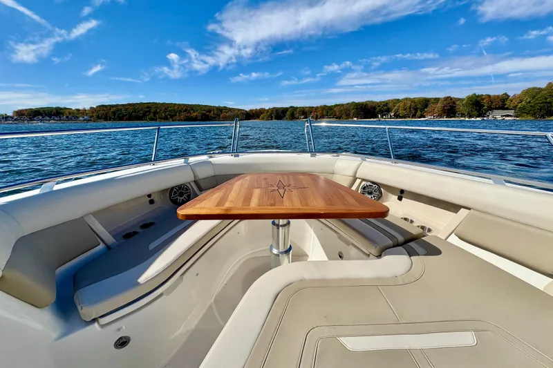  Yacht Photos Pics 2024 Boston Whaler 380 Realm boat interior with wooden table, scenic water view.