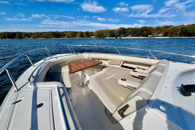  Yacht Photos Pics 2024 Boston Whaler 380 Realm boat interior with seating and table on a sunny day.