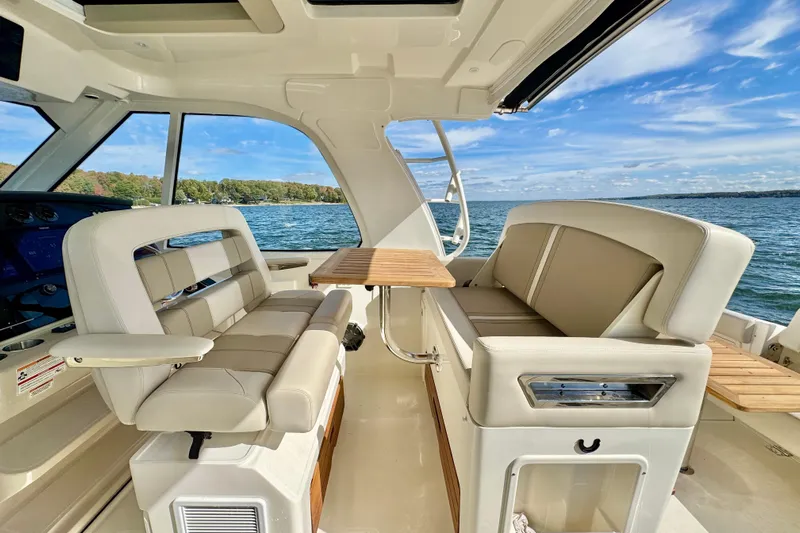  Yacht Photos Pics Interior of 2024 Boston Whaler 380 Realm boat with seating and table, overlooking water.