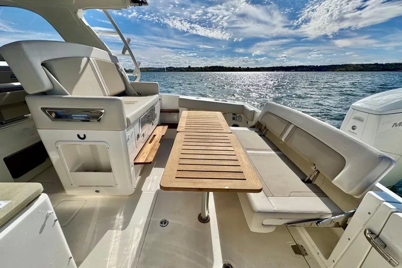  Yacht Photos Pics 2024 Boston Whaler 380 Realm interior with seating and table, overlooking scenic water view.