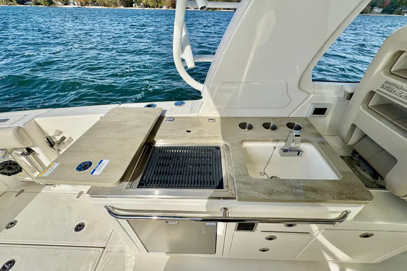  Yacht Photos Pics 2024 Boston Whaler 380 Realm boat kitchen area with sink and grill by the water.