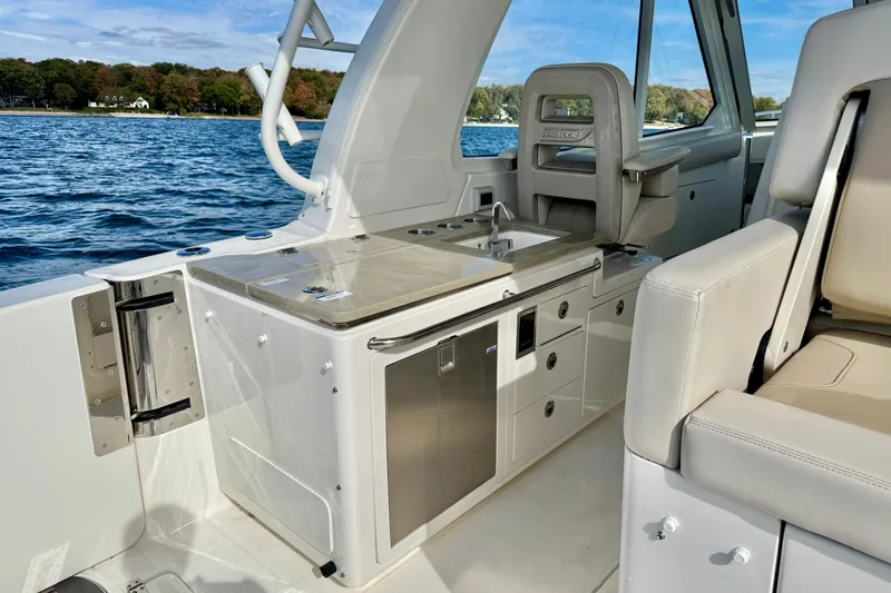  Yacht Photos Pics 2024 Boston Whaler 380 Realm interior with kitchenette and seating, overlooking water.