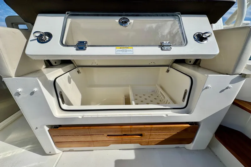  Yacht Photos Pics 2024 Boston Whaler 380 Realm storage compartment with open lid and wooden drawers.