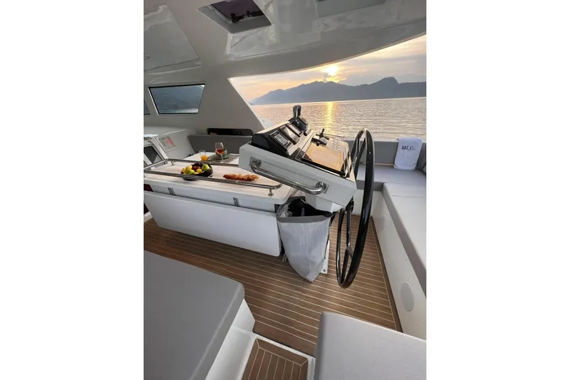 Savoir Faire Yacht Photos Pics Luxurious MCP Global Exp 68 yacht interior with sunset view, featuring elegant helm and dining setup.