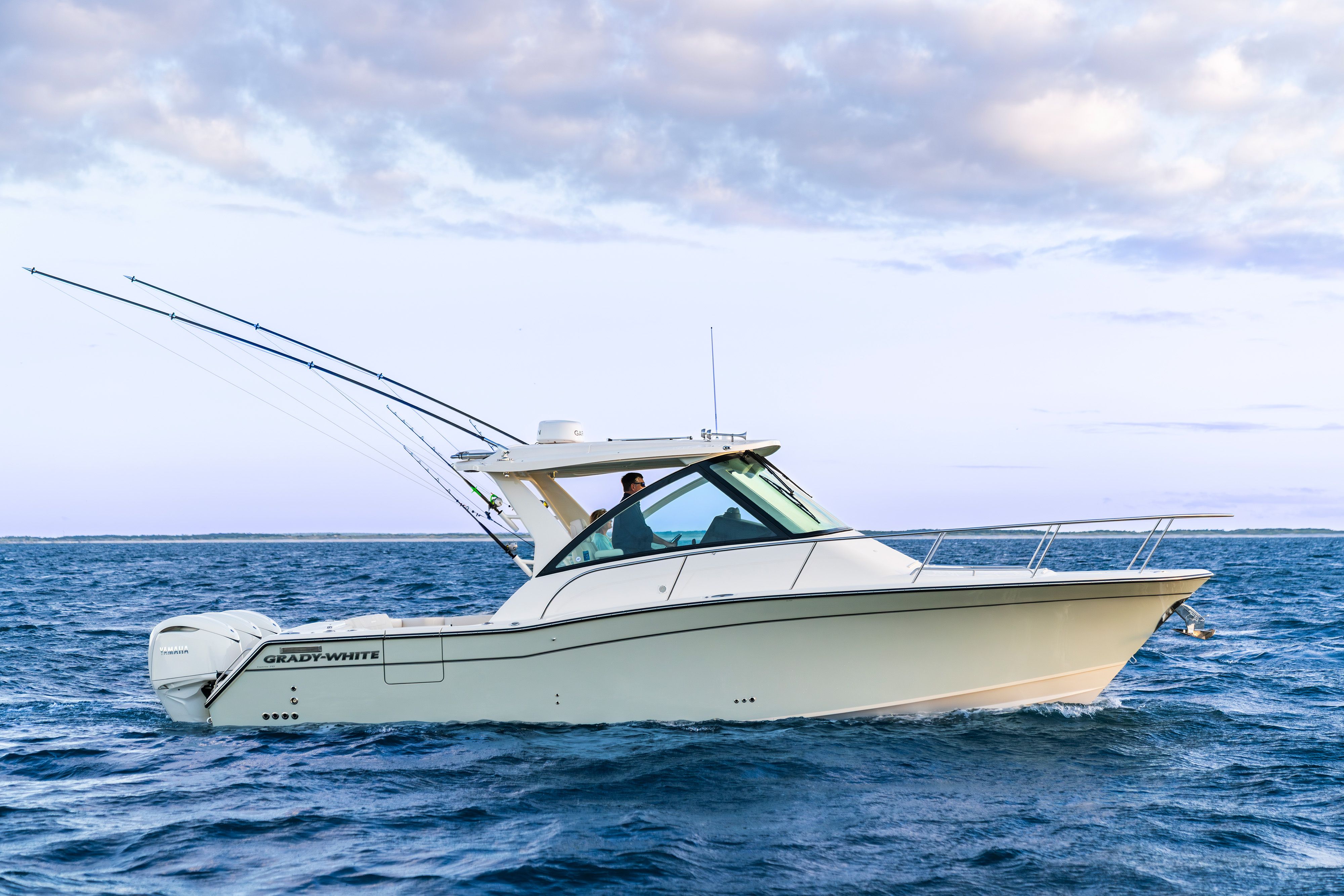 Grady-White 340EXP 2026 boat cruising on open sea at sunset.
