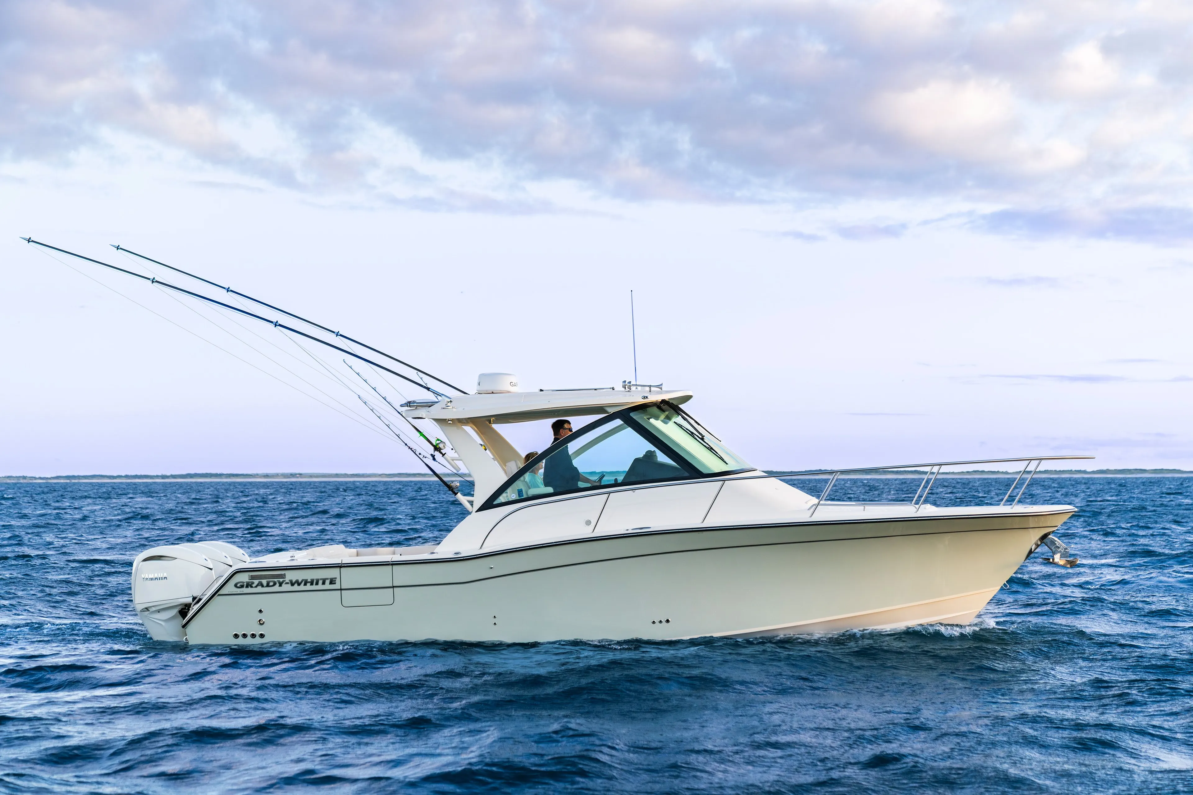 Grady-White 340EXP 2026 boat cruising on open sea at sunset.