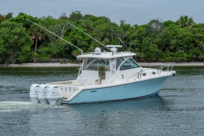 Bottoms Up II Yacht Photos Pics 2009 Pursuit OS 375 Offshore boat cruising near lush green shoreline.