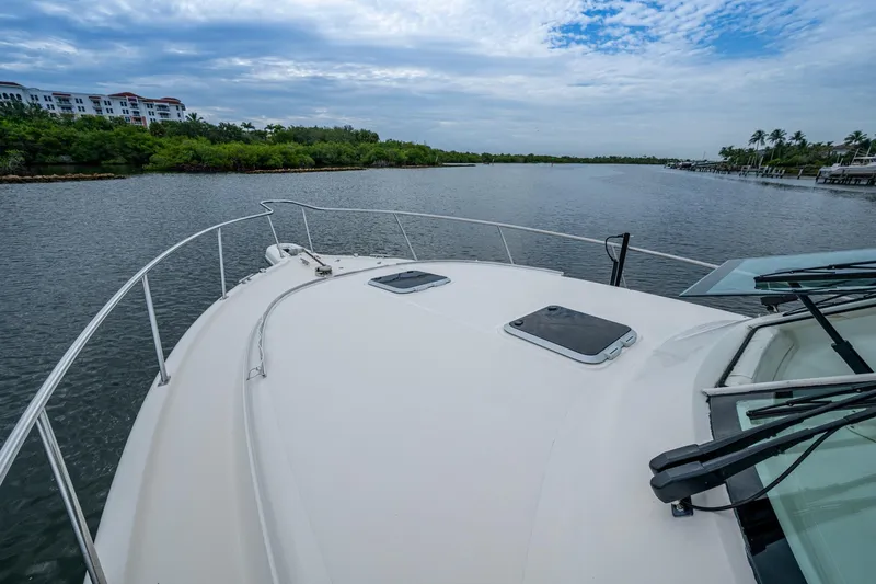 Bottoms Up II Yacht Photos Pics 2009 Pursuit OS 375 Offshore boat on calm water with scenic shoreline view.