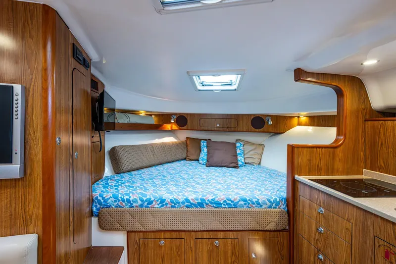 Bottoms Up II Yacht Photos Pics Luxurious cabin interior of 2009 Pursuit OS 375 Offshore boat with cozy bed and wood finish.