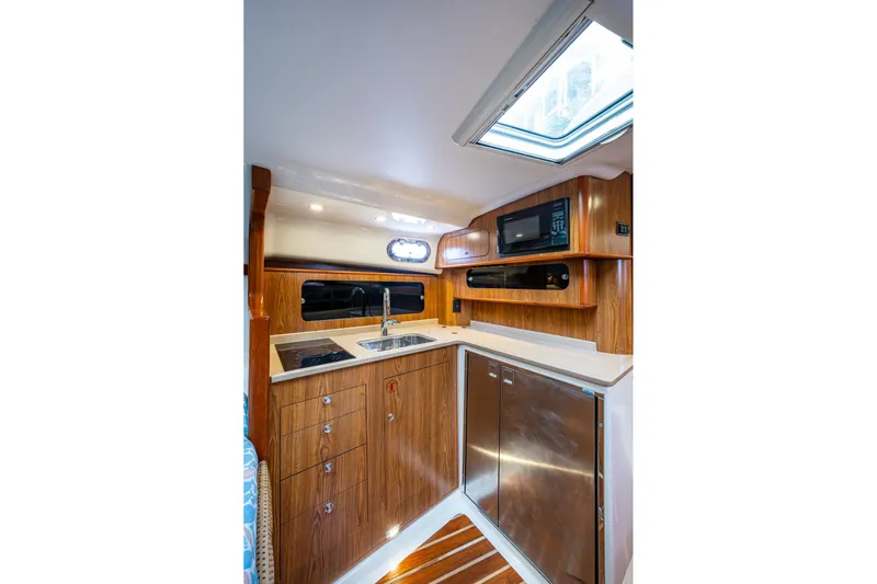 Bottoms Up II Yacht Photos Pics 2009 Pursuit OS 375 Offshore yacht interior kitchen with wood cabinetry and modern appliances.