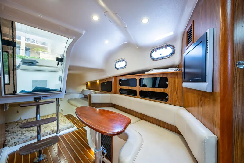Bottoms Up II Yacht Photos Pics 2009 Pursuit OS 375 Offshore cabin interior with wood accents and seating area.
