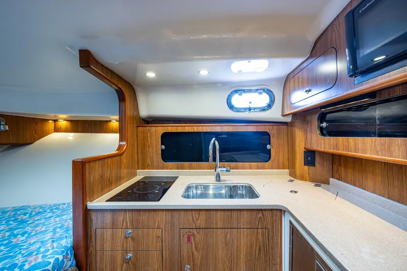 Bottoms Up II Yacht Photos Pics 2009 Pursuit OS 375 Offshore yacht interior with modern kitchen and wood cabinetry.