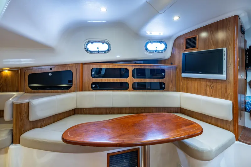 Bottoms Up II Yacht Photos Pics 2009 Pursuit OS 375 Offshore cabin interior with wood accents and seating area.