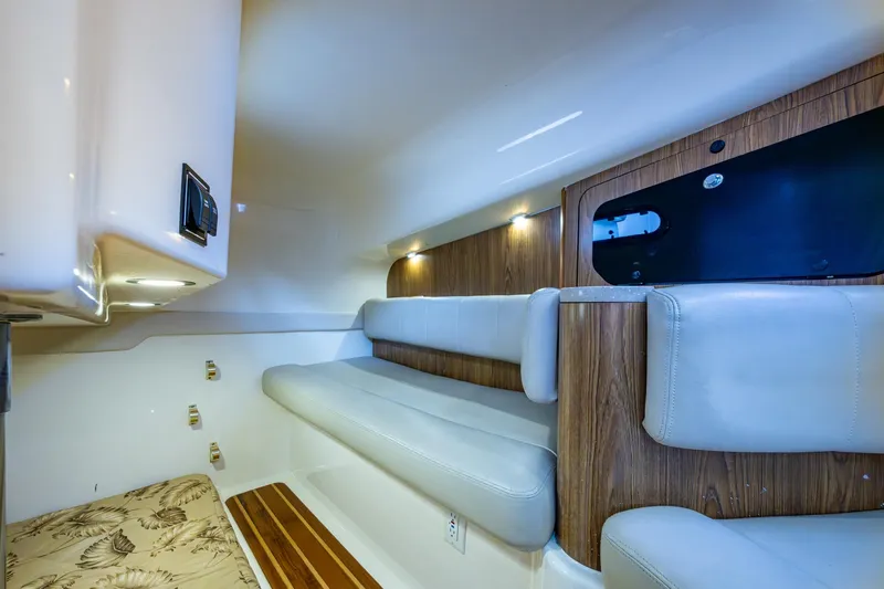 Bottoms Up II Yacht Photos Pics 2009 Pursuit OS 375 Offshore cabin interior with cushioned seating and wood accents.
