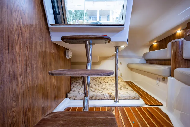 Bottoms Up II Yacht Photos Pics Interior of 2009 Pursuit OS 375 Offshore boat with wooden steps and cozy seating area.