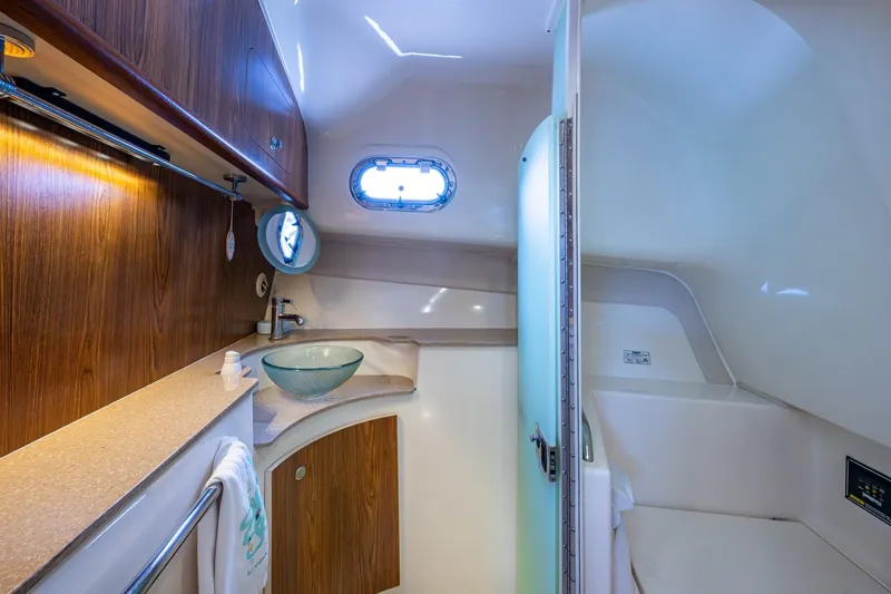 Bottoms Up II Yacht Photos Pics 2009 Pursuit OS 375 Offshore boat bathroom with wood cabinetry and modern fixtures.