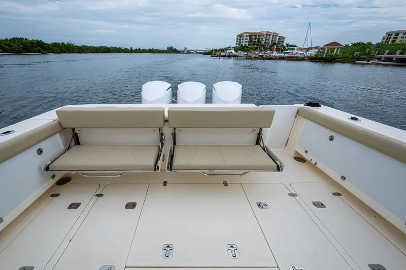 Bottoms Up II Yacht Photos Pics 2009 Pursuit OS 375 Offshore boat with seating, docked near waterfront buildings.