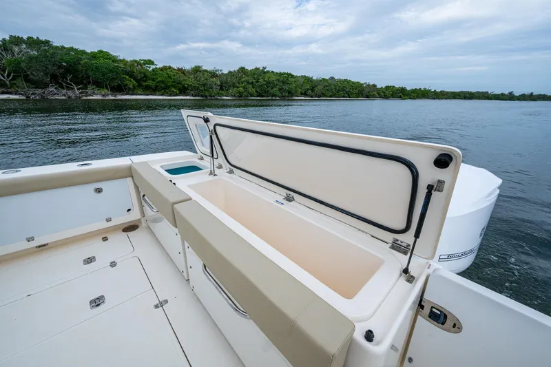 Bottoms Up II Yacht Photos Pics 2009 Pursuit OS 375 Offshore boat with open storage, near lush shoreline.