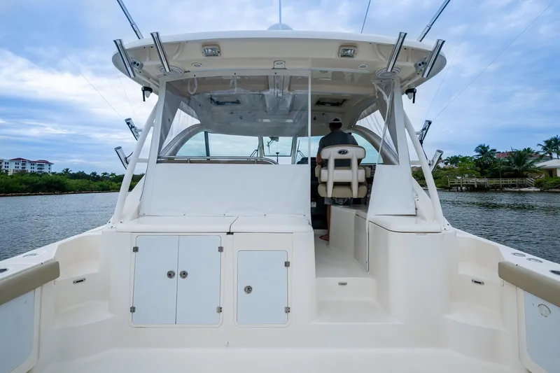 Bottoms Up II Yacht Photos Pics 2009 Pursuit OS 375 Offshore boat interior with helm, on a calm waterway.