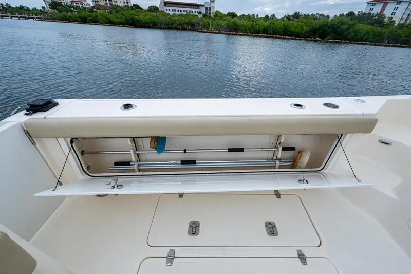 Bottoms Up II Yacht Photos Pics 2009 Pursuit OS 375 Offshore boat with open storage compartment by the water.